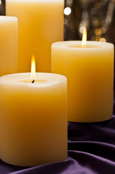 Quatro velas sobre veludo roxo — Fotografia de Stock