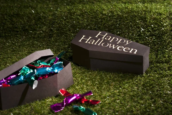 Caixão de Halloween no gramado com doces — Fotografia de Stock