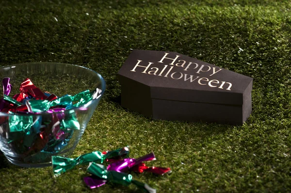 Caixão de Halloween no gramado com doces — Fotografia de Stock