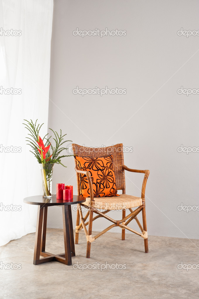 Rattan chair with orange colored pillow