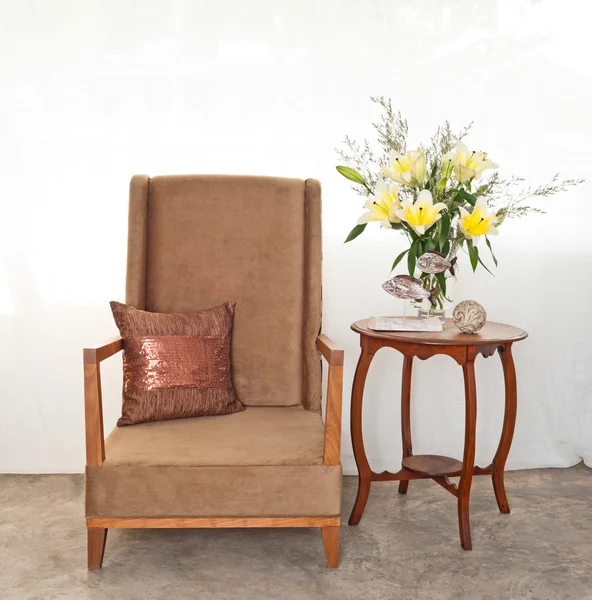 Beige upholstered chair with side table — Stock Photo, Image