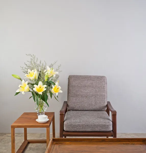 Beige upholstered chair with side table — Stock Photo, Image