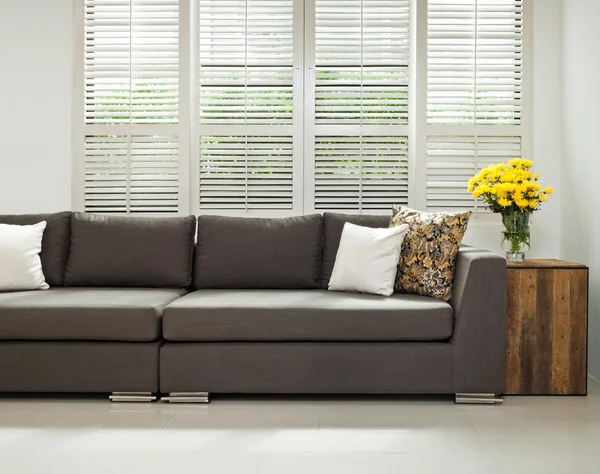 Grey sofa in simple setting — Stock Photo, Image