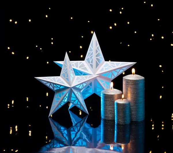 Estrelas retroiluminadas em azul com velas de prata Fotografias De Stock Royalty-Free