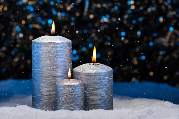 在雪中的三个银蜡烛 — 图库照片