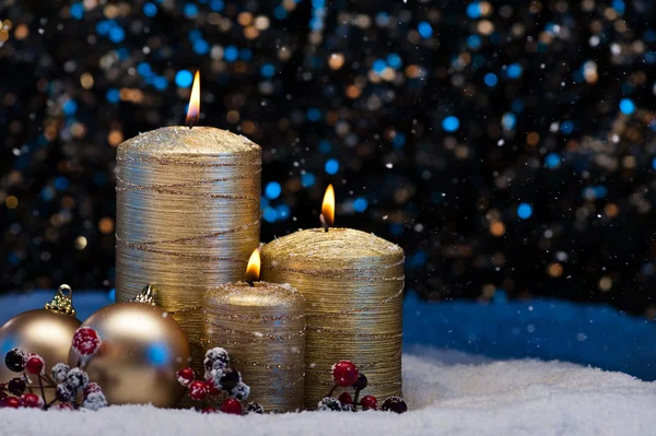 Drie gouden kaarsen in sneeuw — Stockfoto