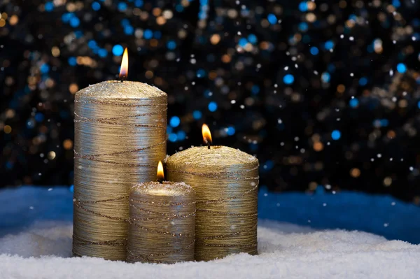 Tre candele d'oro nella neve — Foto Stock