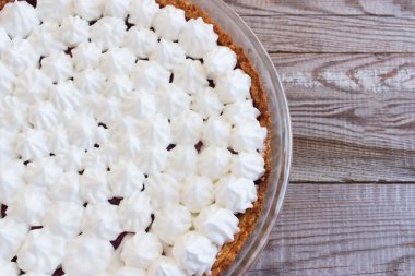 Böğürtlenli küçük kremalı tart kaplı ahşap masa.