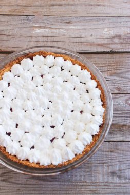 Böğürtlenli küçük kremalı tart kaplı ahşap masa.