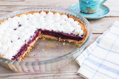 Küçük kremalı tart ahşap masa mavi bardak seramik tabağı.