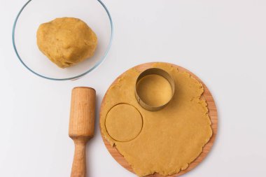 Shortcrust pastry and rolling pin on white background.
