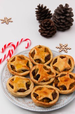 Christmas mince pies and pine cones on white background.