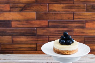 Yuvarlak peynirli kek, beyaz çay tabağının üstünde..