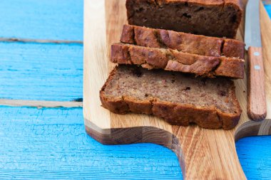 Mavi ahşap zemin üzerinde dilimlenmiş muz ekmeği.