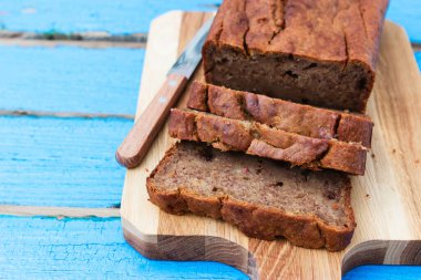 Mavi ahşap zemin üzerinde dilimlenmiş muz ekmeği.