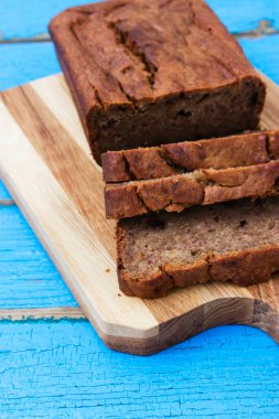 Mavi ahşap zemin üzerinde dilimlenmiş muz ekmeği.