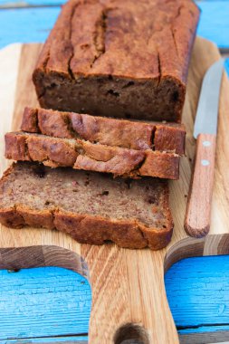 Mavi ahşap zemin üzerinde dilimlenmiş muz ekmeği.