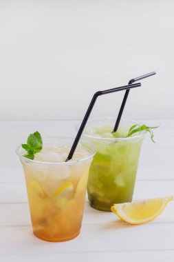 Alkolsüz plastik bardak beyaz ahşap arka plan limonata narenciye nane.