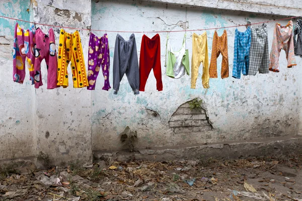 Calça de criança colorida está secando depois de louro na rua Fotos De Bancos De Imagens