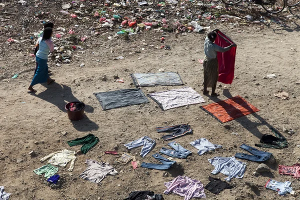 Mulher wark para secar roupas no chão — Fotografia de Stock