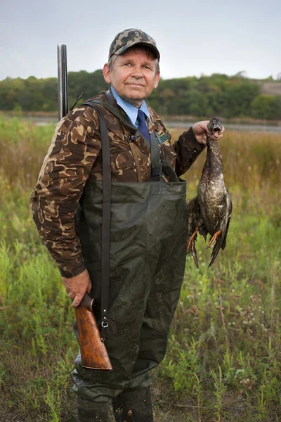 Hombre con arma traer un pato — Foto de Stock