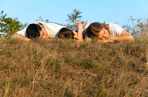 Familie schläft im Gras Stockbild