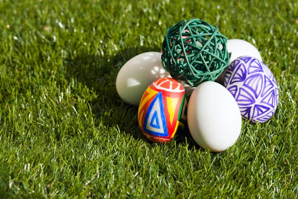 Colorful eggs keep green sphere — Stock Photo, Image