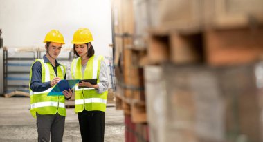 Depo çalışanı büyük bir mağazadaki paketlere bakıyor.