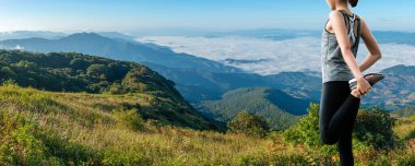 Dişi patika koşucusu bir dağ yolunda koşmadan önce ısınıyor.