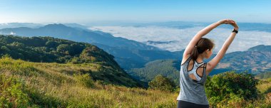 Dişi patika koşucusu bir dağ yolunda koşmadan önce ısınıyor.