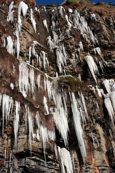 Bevroren ijspegels op een rotswand — Stockfoto