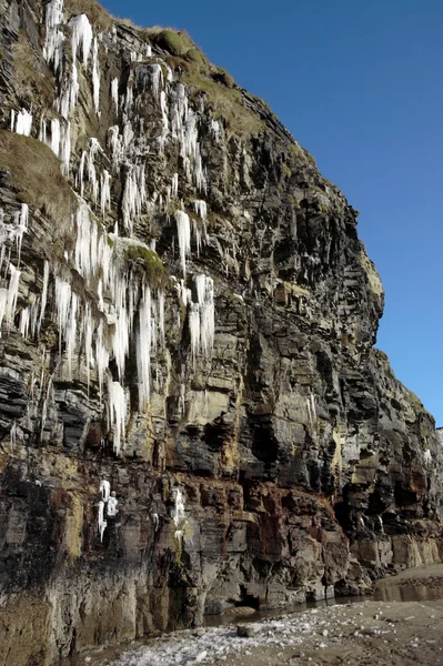 Tauwasserfall von Eiszapfen an einer Felswand — Stockfoto