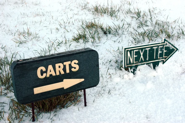 Carritos y el siguiente cartel en un campo de golf cubierto de nieve — Foto de Stock