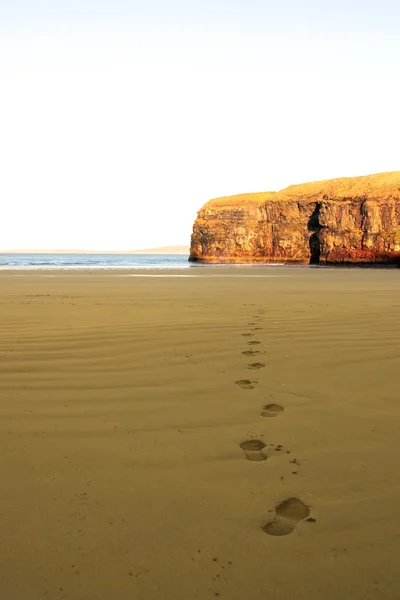 Fußabdrücke im Sand am leeren Strand an einem schönen Wintertag — Stockfoto