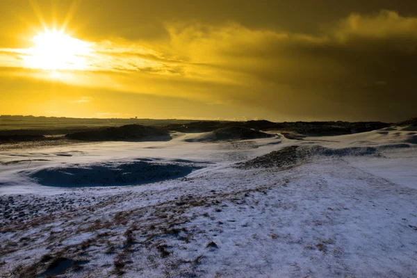 Roter Himmel bei Sonnenuntergang auf einem schneebedeckten Links-Golfplatz — Stockfoto