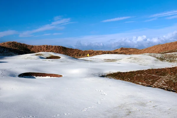 Śnieżne linki kryte pole golfowe z żółtą flagę — Zdjęcie stockowe