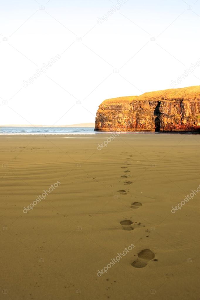 Footprints in sand on empty beach on a beautiful winters day