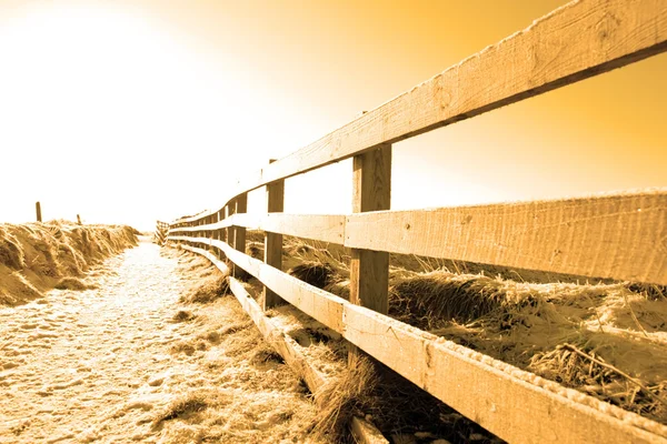 Sendero cubierto de nieve en acantilado caminata vallada al atardecer —  Fotos de Stock