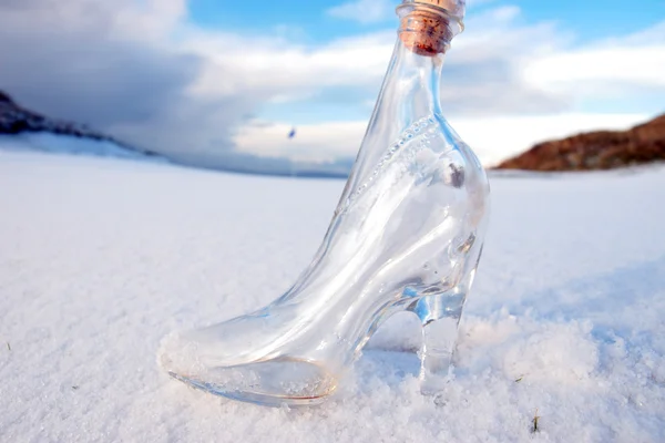 Chinelo de vidro na neve coberto de golfe verde — Fotografia de Stock