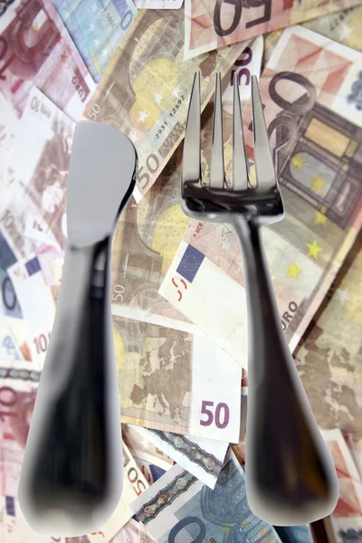 Столовая нож и вилка изолированы в деньгах — стоковое фото