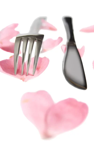 Silver knife and fork isolated with rose petals — Stock Photo, Image