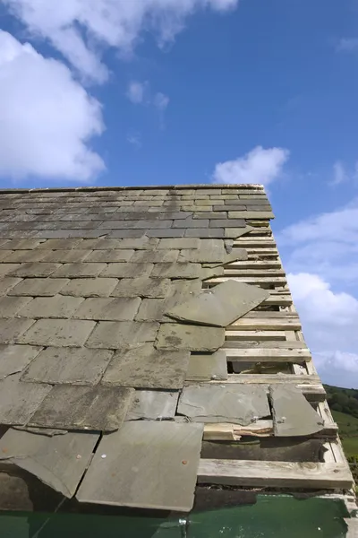 Damaged roof with broken slates — Stock Photo, Image