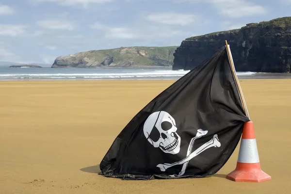 Золотой пляж с веселым флагом Роджера — стоковое фото