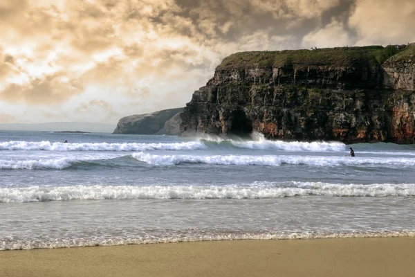 Surfistas cerca de acantilados antes de una tormenta — Stockfoto