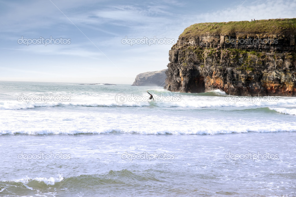 lone surfer near cliffs