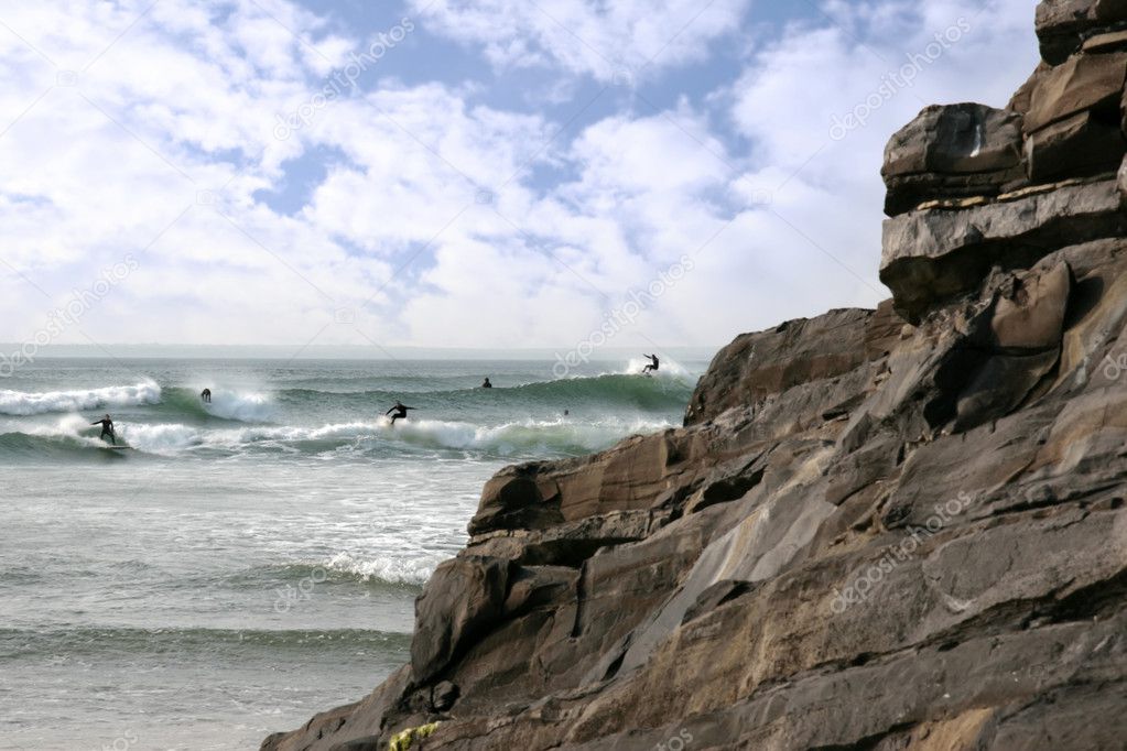 surfers near rocks