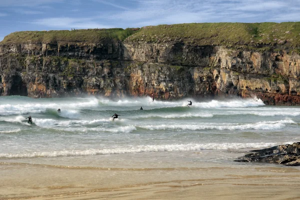 Surfisti concorrenza vicino scogliere — Foto Stock