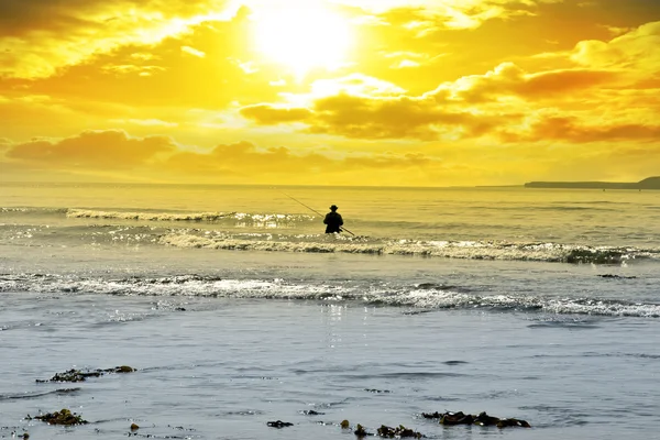 Hombre pescando entre las olas — Foto de Stock