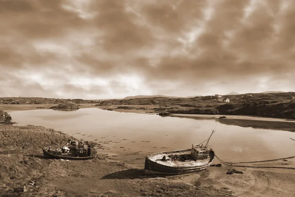 Twee beached vissersboten op Ierse strand in sepia — Stockfoto