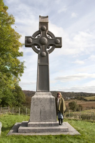 Touristin am irischen Denkmal keltisches Kreuz — Stockfoto